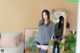 A woman standing in front of a mirror in a bedroom.