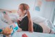 A woman laying on a bed with headphones on.