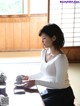 A woman sitting at a table with a cup of tea.