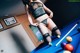 A woman in lingerie and stockings playing pool.