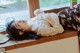 A woman laying on a window sill next to a plate of food.