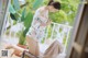 A woman in a white dress sitting on a chair.